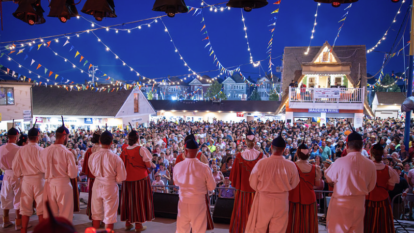A photo from the main stage at the Feast of the Blessed Sacrament behind traditional folkloric dancers looking out to a large festival crowd in August in New Bedford.
